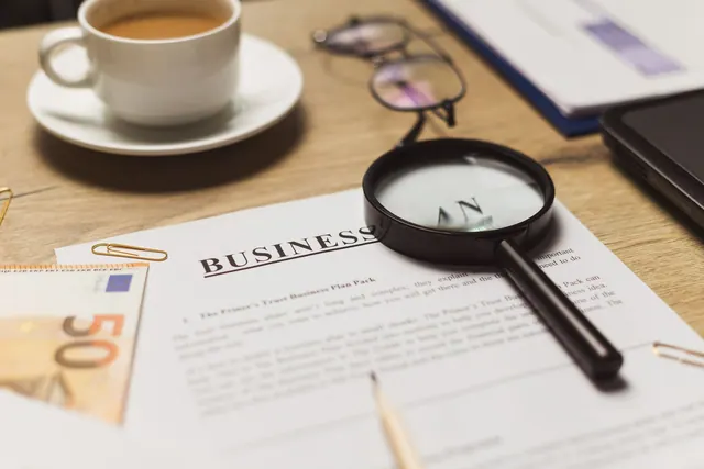 A business workspace setup featuring documents, coffee, and financial elements. Entity type selection guide: examples and useful context