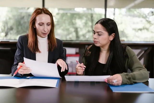 Two professional women reviewing documents in a well-lit office setting. Entity type selection questions: what to know and why