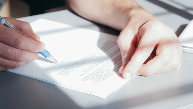 Hands signing a contract with a blue pen, close-up view. LLC formation examples worth studying before you start